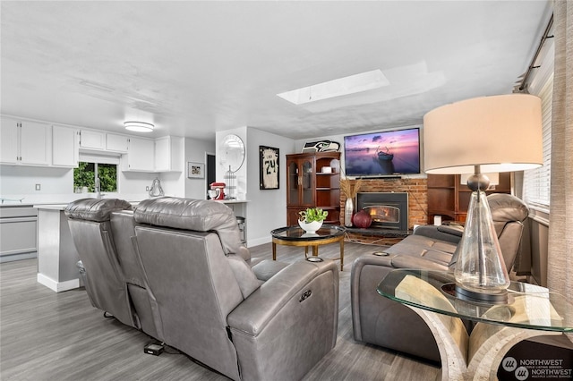 living room with a skylight and light wood-type flooring