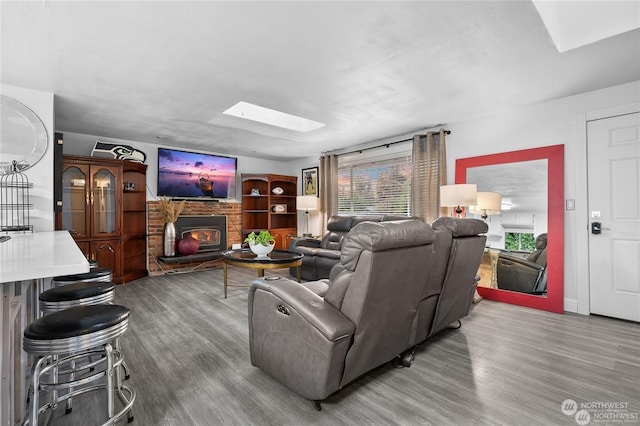 living room with wood-type flooring and a skylight