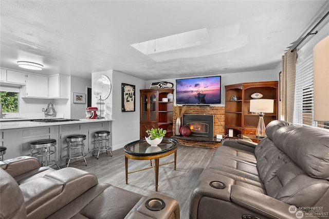 living room with light hardwood / wood-style floors and a skylight