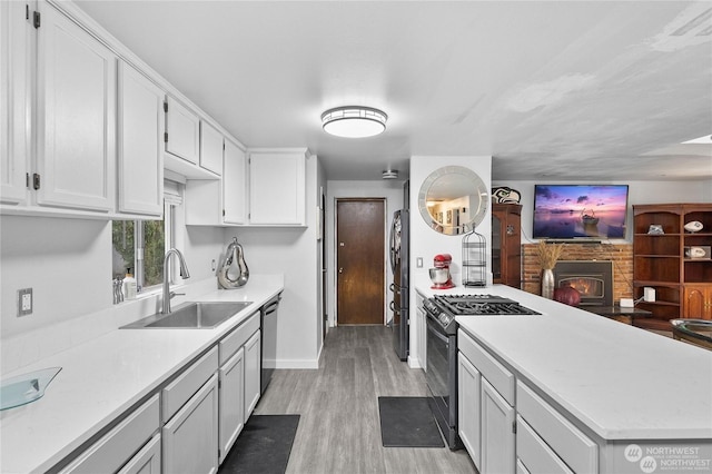 kitchen featuring stainless steel appliances, sink, light hardwood / wood-style flooring, and white cabinets