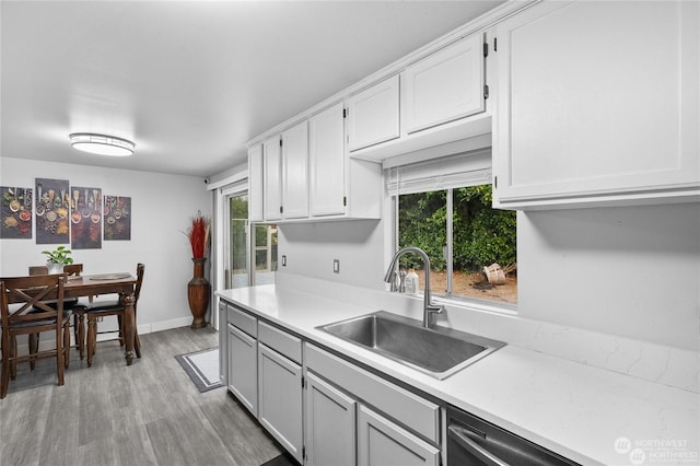 kitchen with dishwasher, sink, white cabinets, and light wood-type flooring