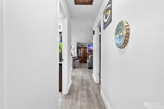 corridor with light hardwood / wood-style flooring