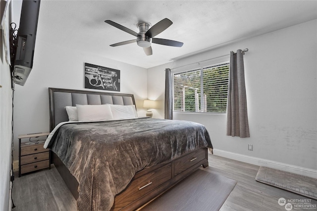 bedroom with dark hardwood / wood-style floors and ceiling fan