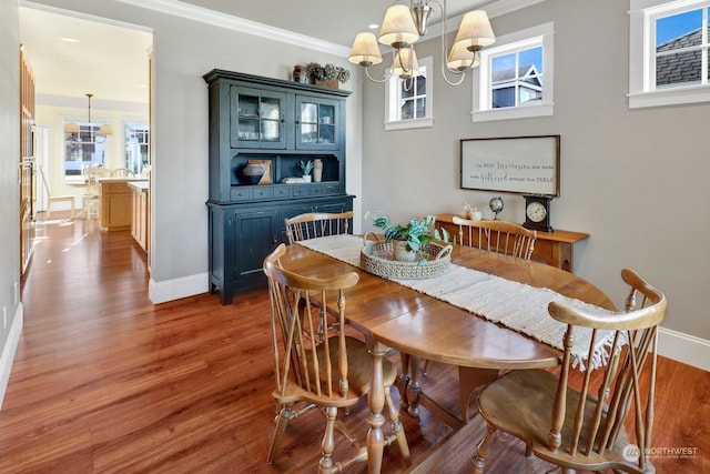 dining space featuring an inviting chandelier, dark wood-type flooring, and ornamental molding