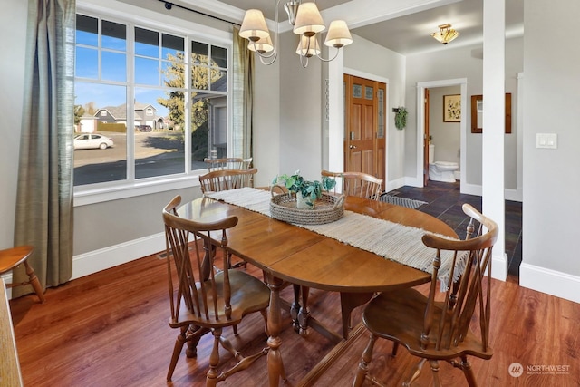 dining space featuring dark hardwood / wood-style floors and an inviting chandelier