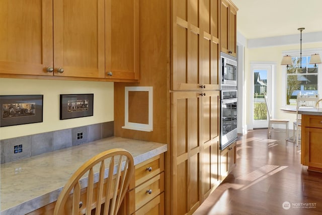 kitchen with dark hardwood / wood-style flooring, appliances with stainless steel finishes, pendant lighting, and an inviting chandelier