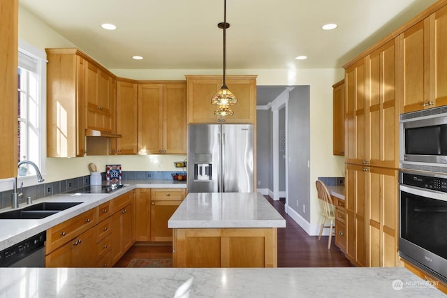 kitchen featuring a kitchen island, a wealth of natural light, decorative light fixtures, sink, and stainless steel appliances