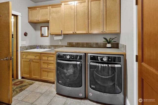 laundry room with sink, light tile patterned floors, cabinets, and independent washer and dryer