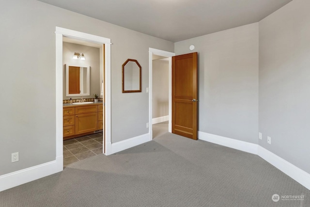 unfurnished bedroom featuring carpet flooring, sink, and ensuite bathroom