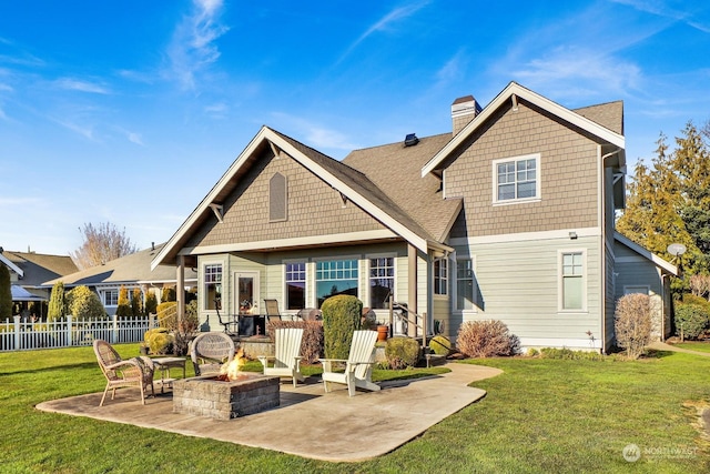 rear view of house with a patio, a fire pit, and a lawn