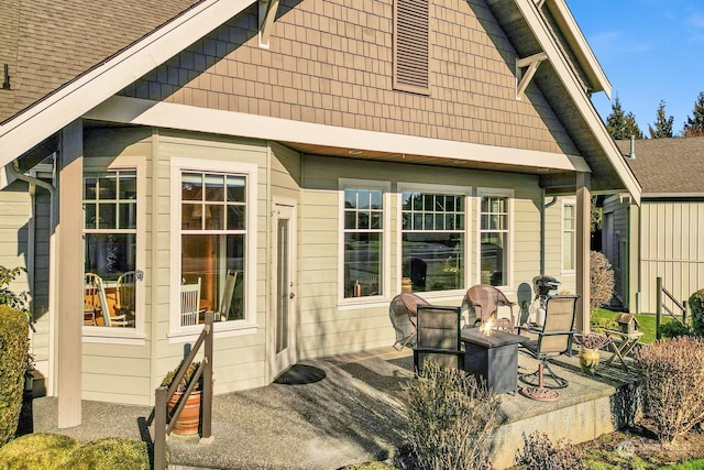 view of side of property with a patio area and an outdoor fire pit