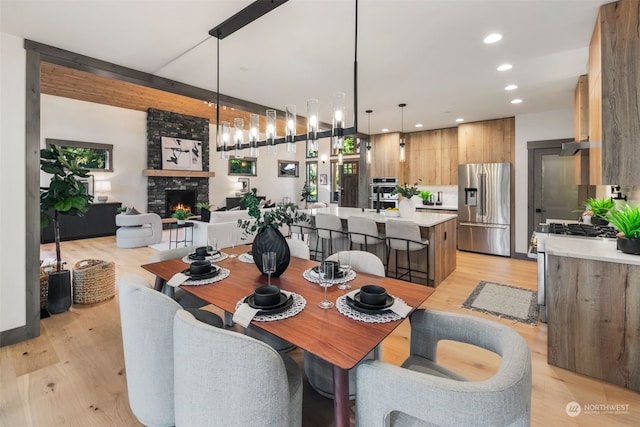 dining area featuring a fireplace and light hardwood / wood-style floors