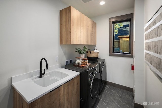 laundry area with cabinets, sink, dark tile patterned flooring, and independent washer and dryer