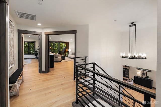 hallway featuring a notable chandelier and light wood-type flooring