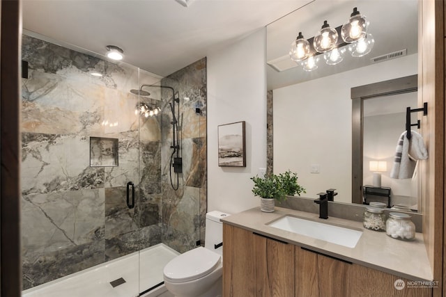 bathroom featuring vanity, toilet, and a shower with door