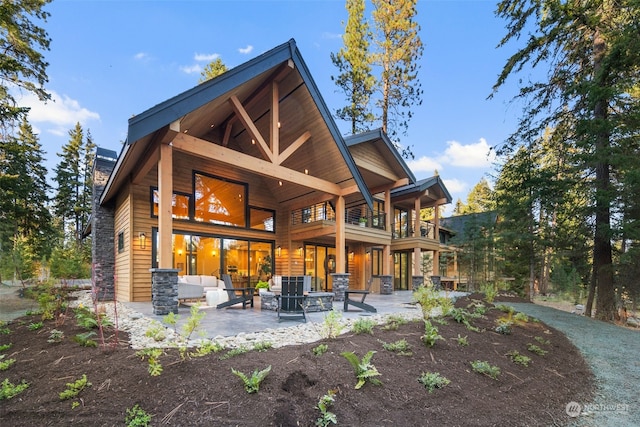 back of property featuring a balcony and a patio