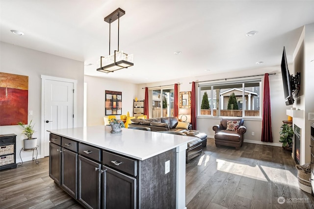 kitchen featuring decorative light fixtures, dark wood-type flooring, and a kitchen island