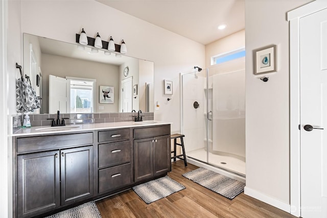 bathroom featuring vanity, wood-type flooring, a shower with door, and plenty of natural light