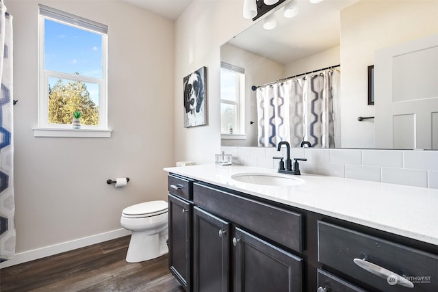 bathroom featuring vanity, hardwood / wood-style flooring, a wealth of natural light, and toilet