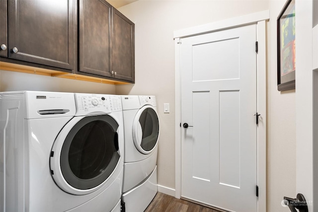 laundry area featuring dark wood-type flooring, cabinets, and washer and dryer