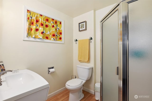 bathroom with sink, hardwood / wood-style floors, toilet, and walk in shower