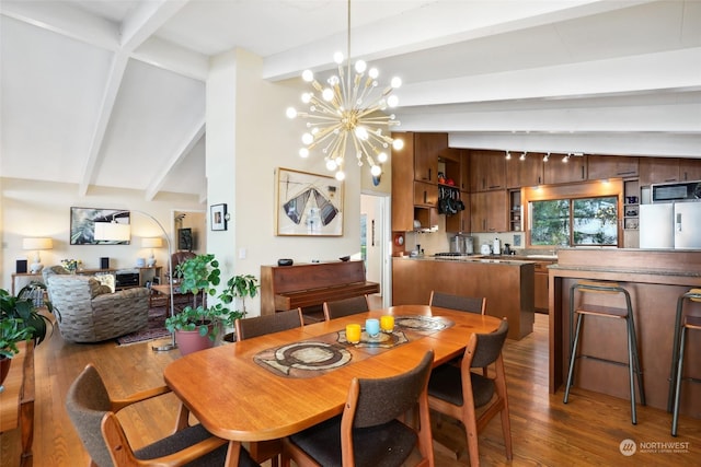 dining space featuring dark hardwood / wood-style floors, a chandelier, and vaulted ceiling with beams