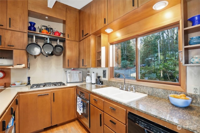 kitchen with stainless steel appliances, plenty of natural light, sink, and light stone counters