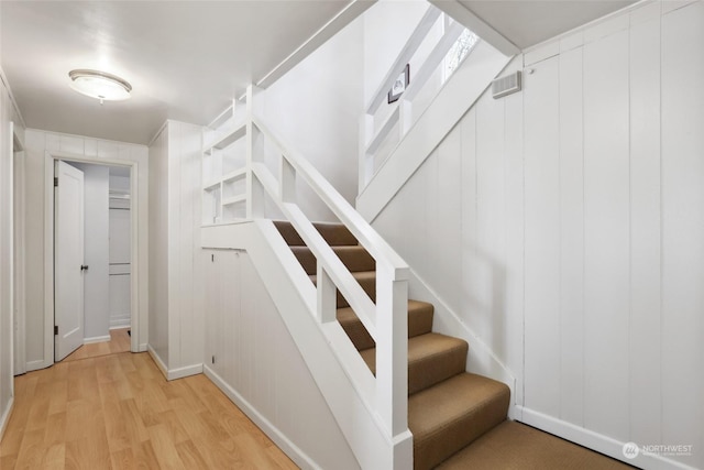 stairs featuring hardwood / wood-style floors