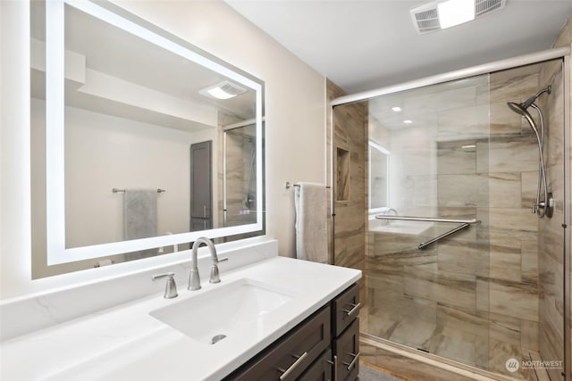 bathroom with a shower with door and vanity