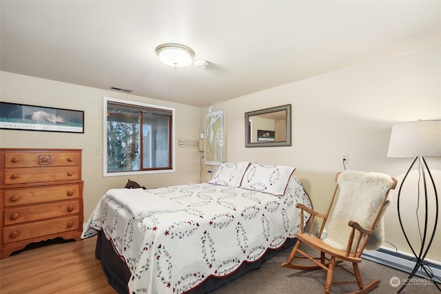 bedroom featuring light hardwood / wood-style flooring and a baseboard radiator