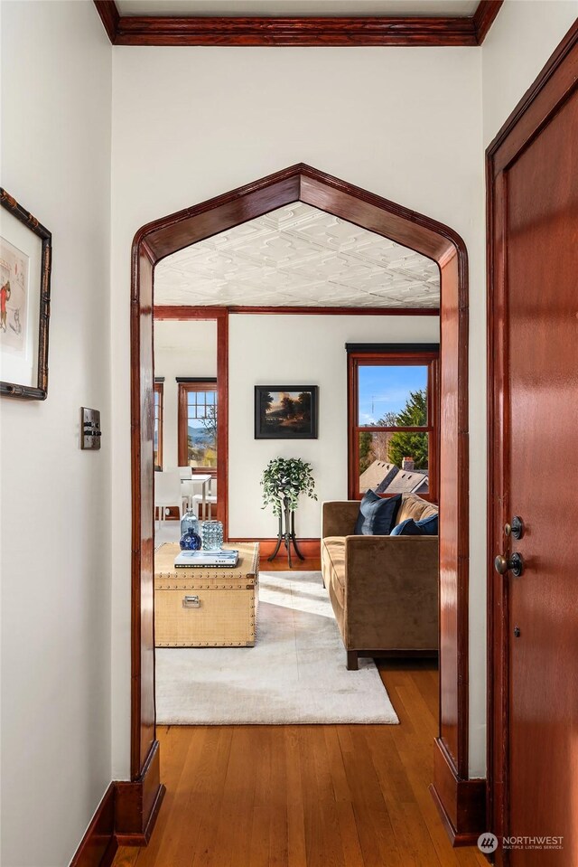 hall with crown molding and hardwood / wood-style flooring