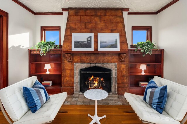 living area with ornamental molding and a tiled fireplace