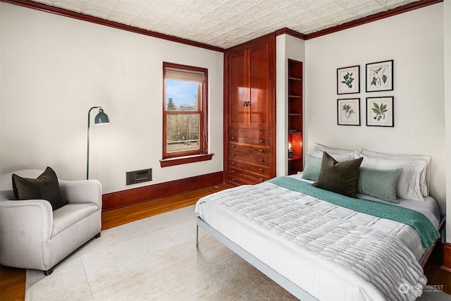 bedroom featuring hardwood / wood-style flooring and crown molding