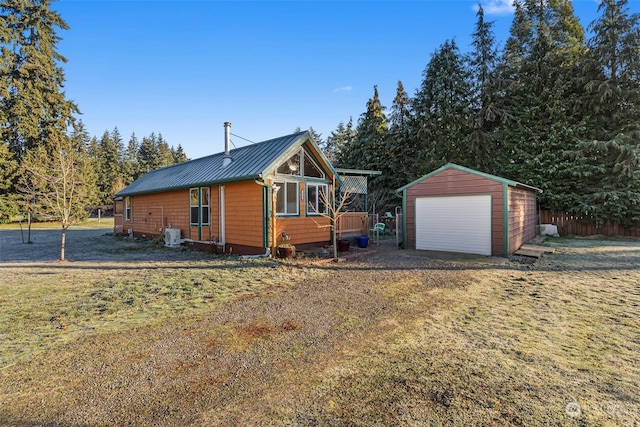 view of front of house with a garage, an outdoor structure, and a front yard