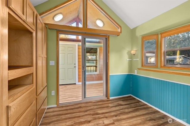 doorway featuring vaulted ceiling and dark hardwood / wood-style floors