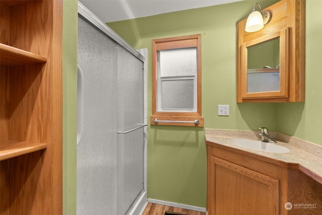 bathroom with vanity and a shower with shower door