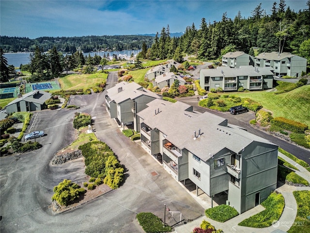 birds eye view of property with a residential view, a water view, and a wooded view