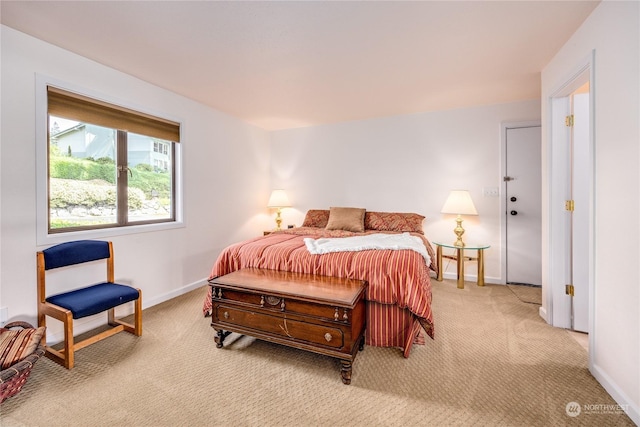 bedroom featuring light colored carpet and baseboards