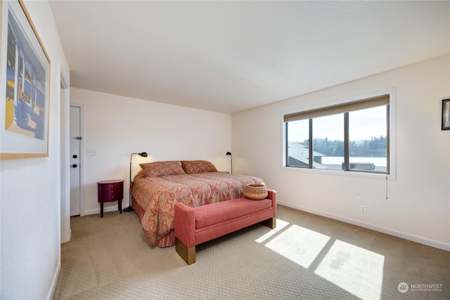 bedroom featuring light colored carpet and baseboards