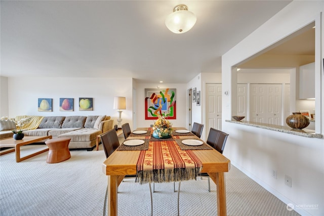 carpeted dining space with baseboards