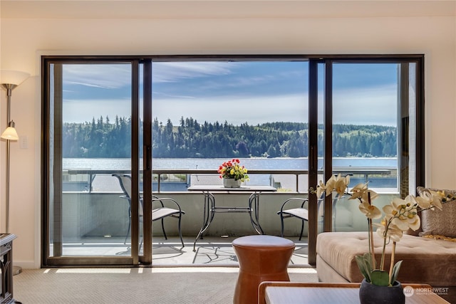 balcony featuring a water view and a wooded view