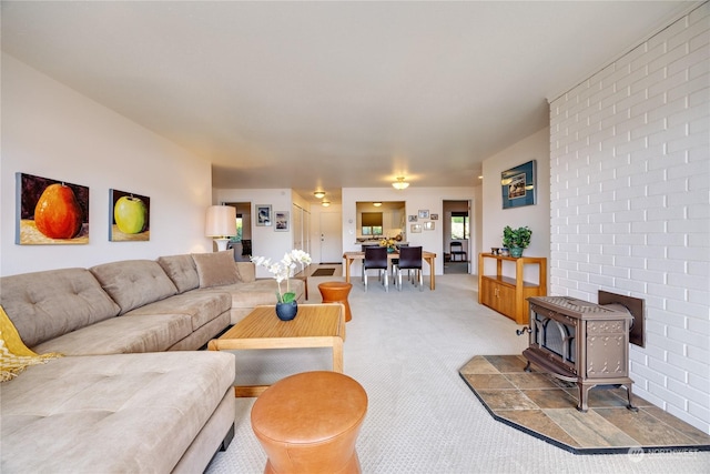 living room featuring light carpet and a wood stove