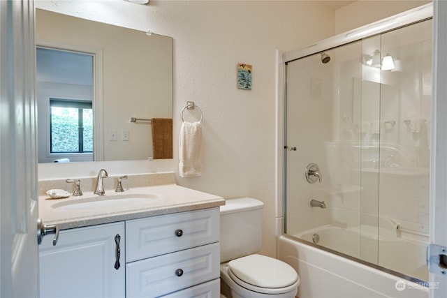 bathroom featuring vanity, toilet, and bath / shower combo with glass door