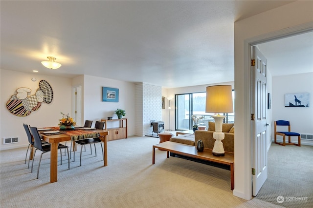 living area featuring light colored carpet, visible vents, and baseboards