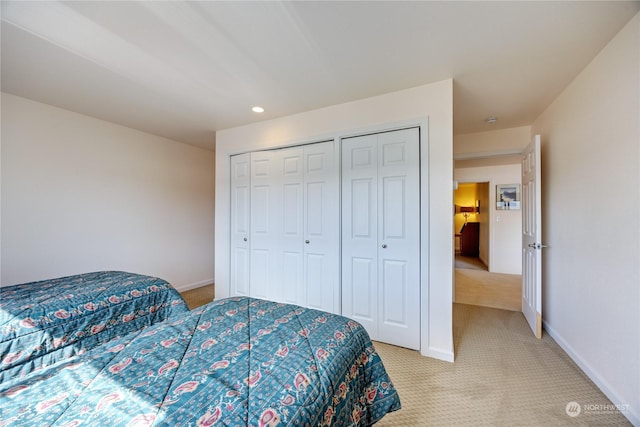 bedroom featuring light carpet, baseboards, two closets, and recessed lighting