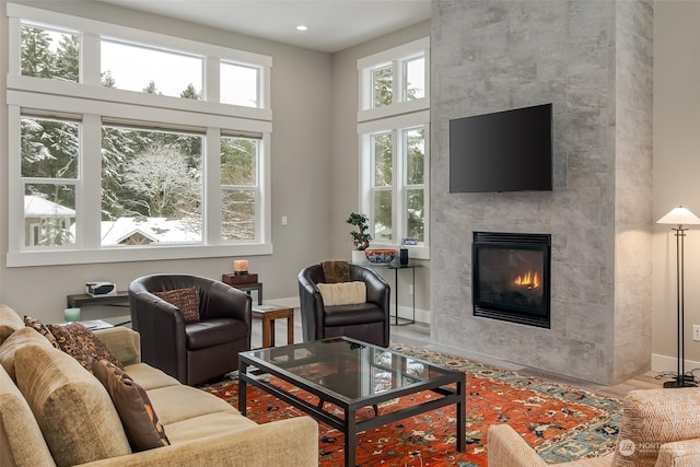 living room featuring a tile fireplace and a healthy amount of sunlight