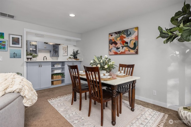 carpeted dining room with bar area