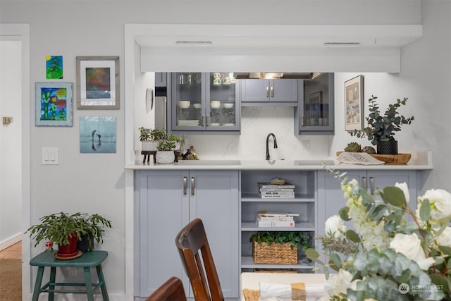 bar with tasteful backsplash, sink, and gray cabinetry