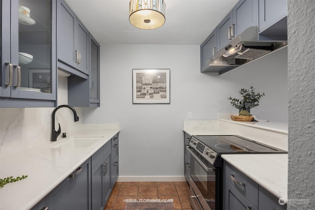 kitchen with gray cabinetry, dark tile patterned flooring, sink, and electric range