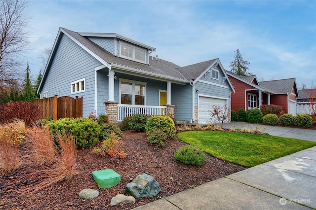 view of front of home featuring a garage, a front lawn, and a porch